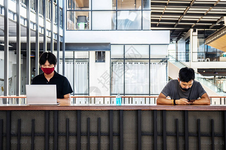 两名亚裔男子在与笔记本电脑合作时图片