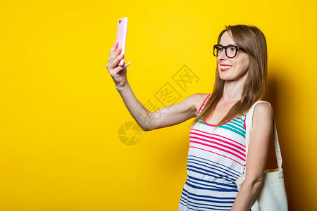 友善笑的年轻女孩拿着电话在黄图片