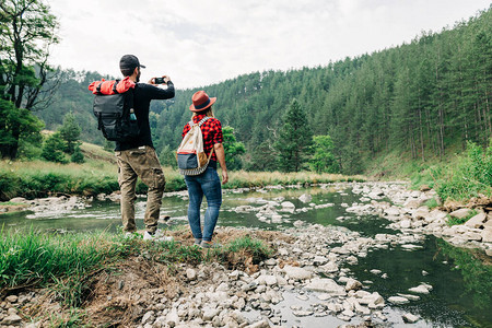 在山河边探索自然的年轻夫妇高清图片