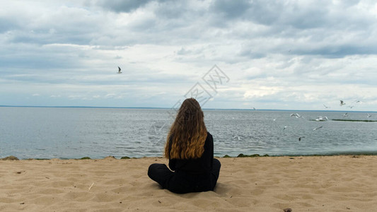 年轻女子坐在海边图片