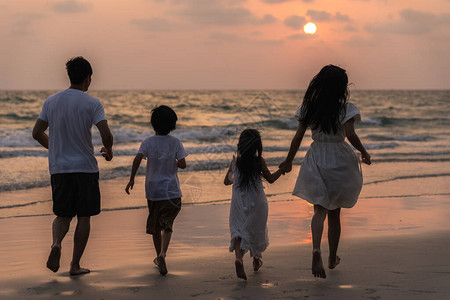 亚洲年轻幸福的家庭晚上在海滩上享受假期图片