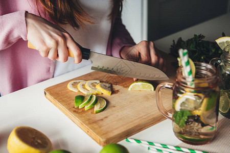 一位姜汁女士在家中用刀子切柠檬时图片