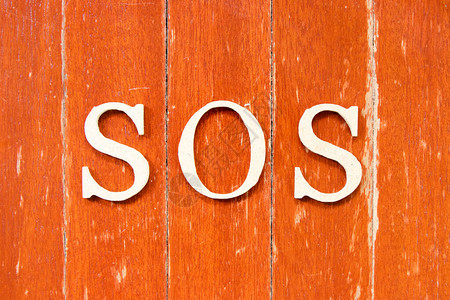 以旧红色木板本底的字母拼字SOS拯救我们的灵魂船或肩背景图片