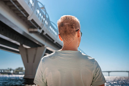 照片来自圣彼得堡西部高速直径汽车桥金属结构背景中一名年轻人背部的照片图片