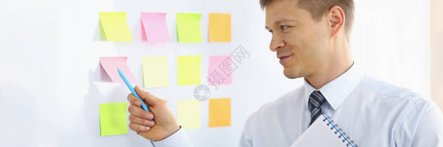 在记号板上的彩色笔记上用钢笔指点的男肖像准备与董事交谈的商人商图片