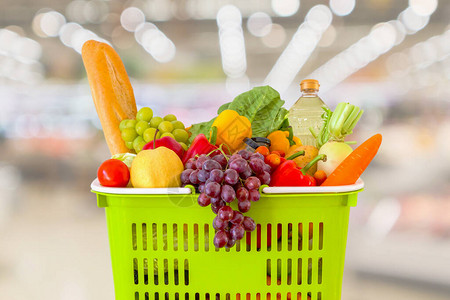 超市杂货店里装满水果和蔬菜的购物篮模糊了散景图片