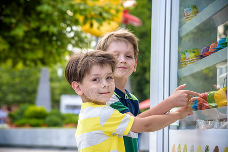 可爱的白人滑稽男孩在商店橱窗里看着冰淇淋图片