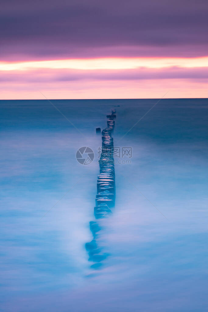 海洋和海水中的断流水上有温暖的粉色紫日落美丽图片