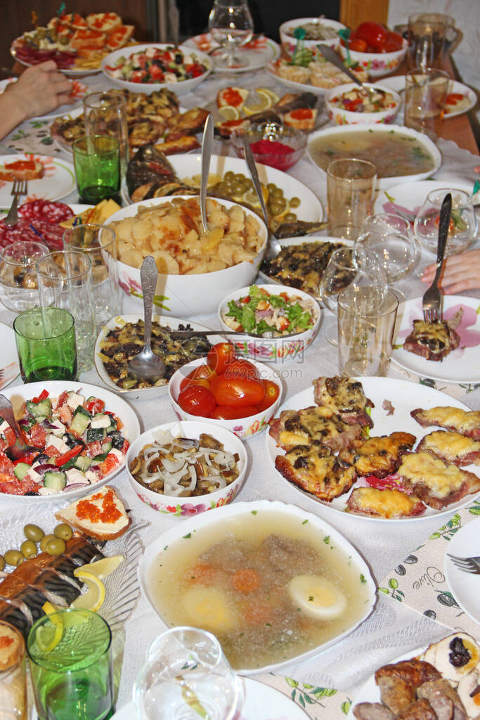 假期表设置与美味菜肴的节日餐桌家庭度假时桌上有很多食物餐桌上供应的节日食品一套不同的肉类和蔬菜肴在图片