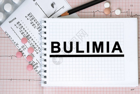 BULIMIA用药丸和铅笔医学概念顶视等表格上带有BULIMIA案文图片