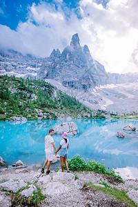 夫妇参观意大利多洛米蒂山的蓝绿色湖泊图片