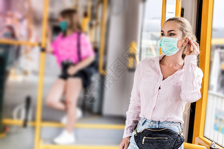 戴着呼吸面罩乘坐公共交通工具的年轻女子冠状期间的公共交通概念冠状图片