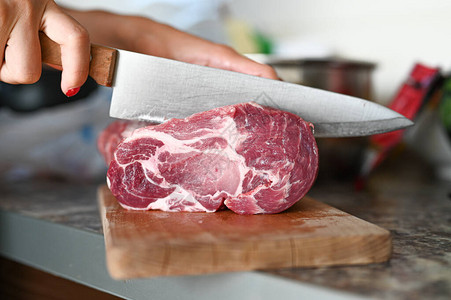 一个女孩用一把大刀切了一块肉背景图片