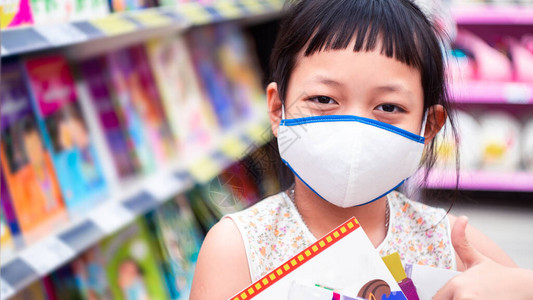 亚洲女童在文具店里戴面罩和购买学习用品回到学校概念中去backtos图片