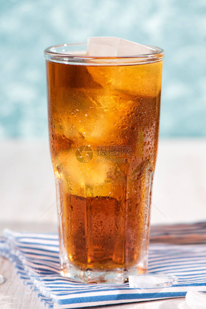木桌上的一杯冰茶自由古巴或长岛鸡尾酒冷饮或柠檬水加柠檬和罗勒背景上图片