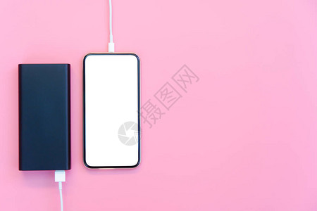智能手机在粉红色背景下使用移动电源充电图片