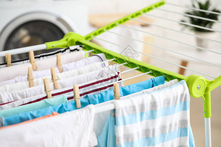 干净的衣服挂在洗衣房的烘干机上特写图片