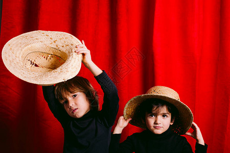 两名男孩身着黑色衣服和一间稻草棚图片
