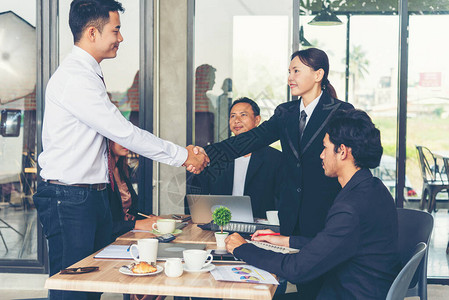 团队业务合作伙伴一起握手问候在会议室开办小型企业握手的团队合作伙伴在现代办公室握背景图片