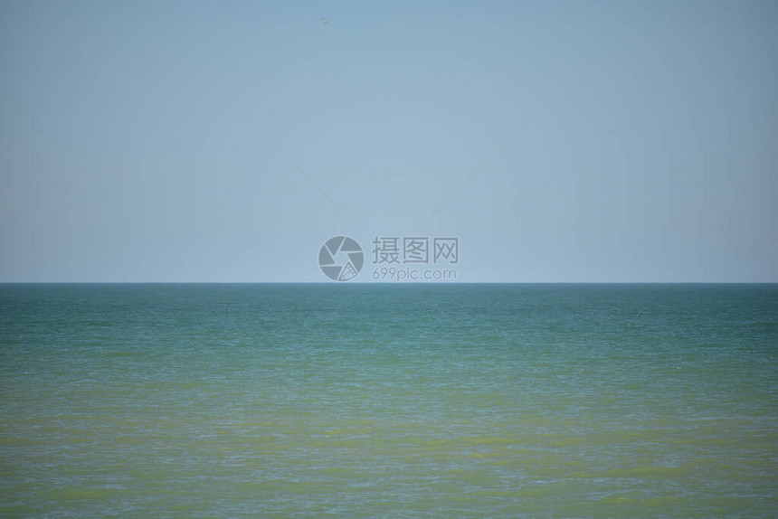 平静的海面与美丽的蓝天海平静的天空平静的海面在晴朗的天空下图片