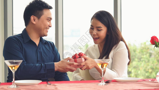 浪漫情侣赠送礼物给餐厅的爱人快乐的图片