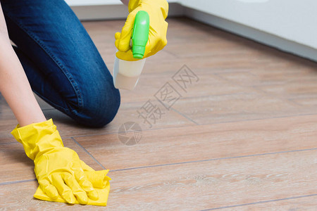 一个女孩正在用黄色手套洗地板一个女孩正在用洗高清图片