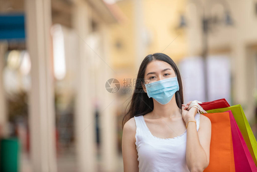 亚裔妇女在购物商场持有购物袋图片