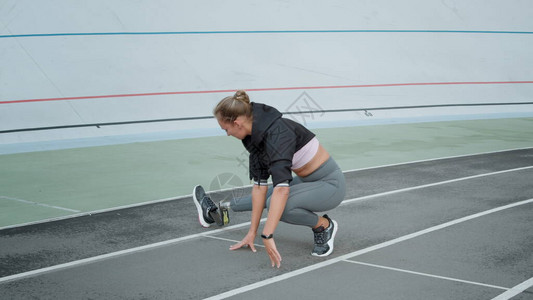 残疾妇女在跑道上伸展双腿运动型女士准备在户外慢动作锻炼在体育场锻炼图片
