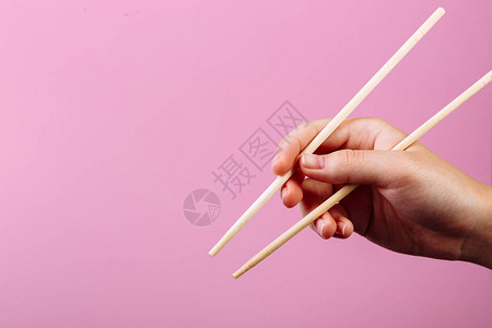 手握筷子粉红色背景标题和文字图片