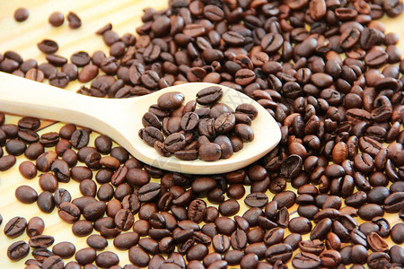 木勺中的天然黑咖啡豆图片