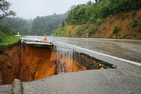 暴雨造成的山体滑坡发生断路沥青街上的破水泥被大雨摧毁的山体滑图片