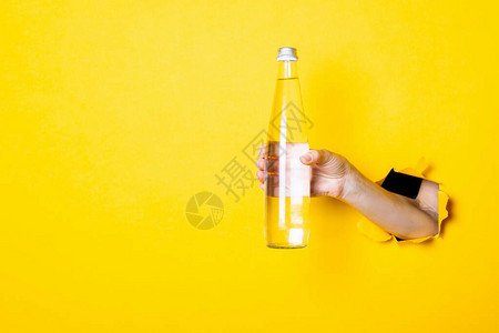 女手握着一个装有水的玻璃瓶图片