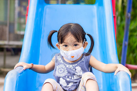 2岁婴儿的肖像图快乐的亚洲女孩微笑着戴织物面具背景图片