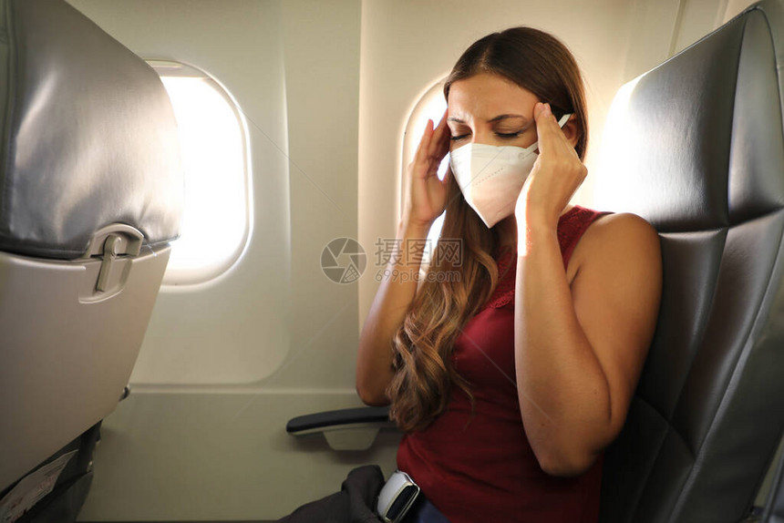 COVID19戴KN95FFP2面罩的年轻女在飞机上感觉不适害怕在飞机上飞行的女人大流行期间飞机上的压力头痛图片
