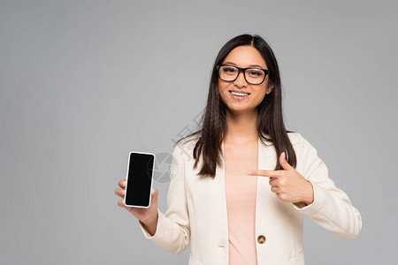 眼镜中的年轻女商人用手指对着智能手机用灰色隔开的空图片