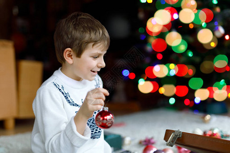 漂亮的孩子男孩和五颜六色的老式圣诞玩具和旧手提箱里的球图片