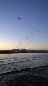 客机在埃及的夕阳高山和大海中翱翔图片