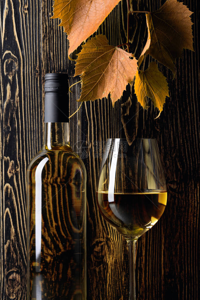白葡萄酒和葡萄酒在旧木制背景图片
