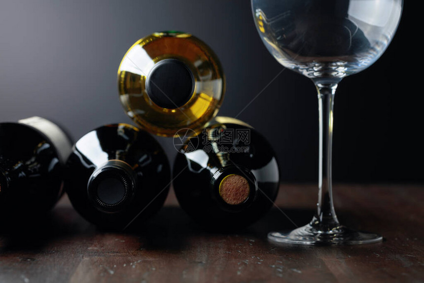 未开封的红葡萄酒和白葡萄酒瓶旧木桌上的酒瓶和空酒图片