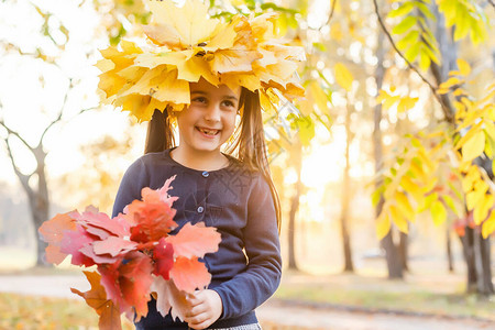 快乐的小女孩女孩在秋天欢笑和玩耍在大图片