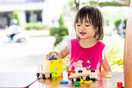 亚洲女婴玩木块玩具的肖像图在木桌上2岁的孩子孩子概念的和发展图片