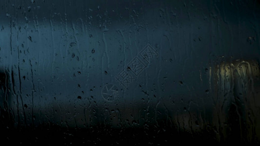 水滴在深夜城市背景下的窗户上滴下图片