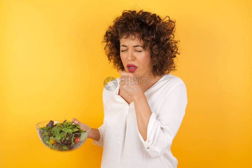 Beeauitul妇女拿着沙拉碗不舒服和咳嗽作为感冒或支图片