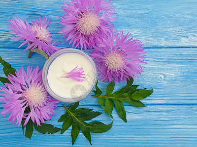 木制背景紫锥菊上的奶油化妆品花图片