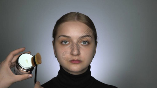 化妆师在美容工作室为年轻女制作专业化妆化妆师涂抹底妆图片