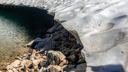 夏季冰川和岩石融化的冰湖部分冷冻意大利奥斯塔谷的风景气候变图片