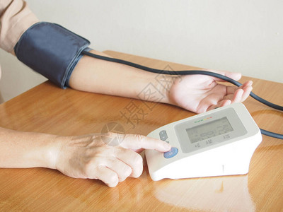 中年妇女在家用自动血压计测量她的血压和心率医疗保图片