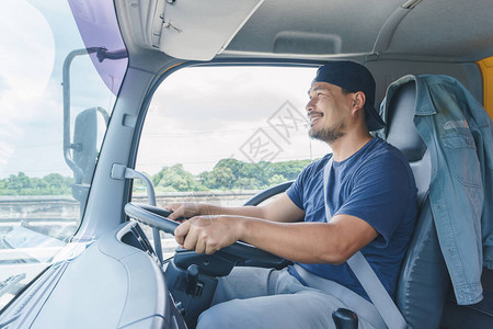 长途商业运输中年轻男子专业卡车驾驶车手的图片