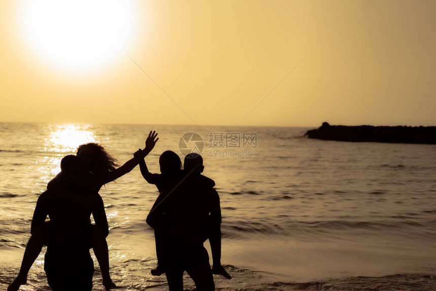 日落时在海上附近人们的轮廓年轻人暑假过得很愉快旅行聚会和友图片