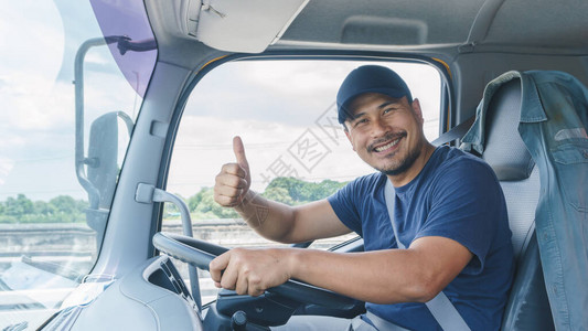 长途商业运输中年轻男子专业卡车驾驶车手的图片